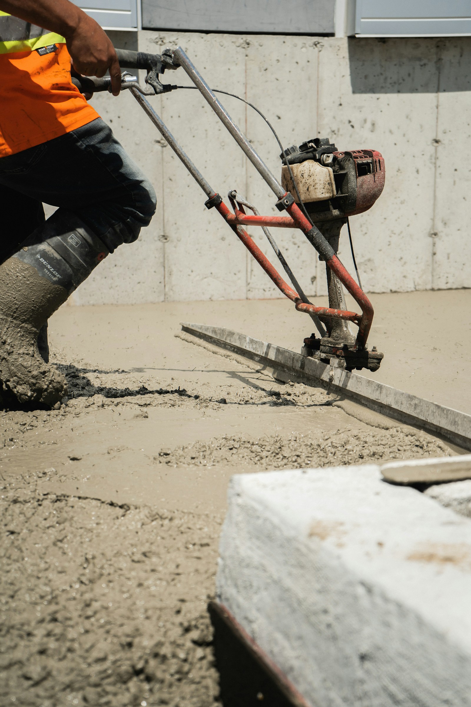 Worker finishing a fresh concrete surface